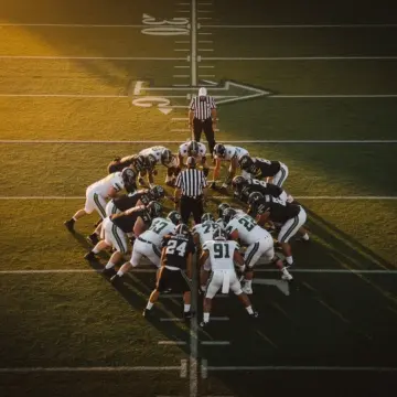 NFL player on sideline with trainer illustrating NFL injuries impact on 2026 offseason rosters